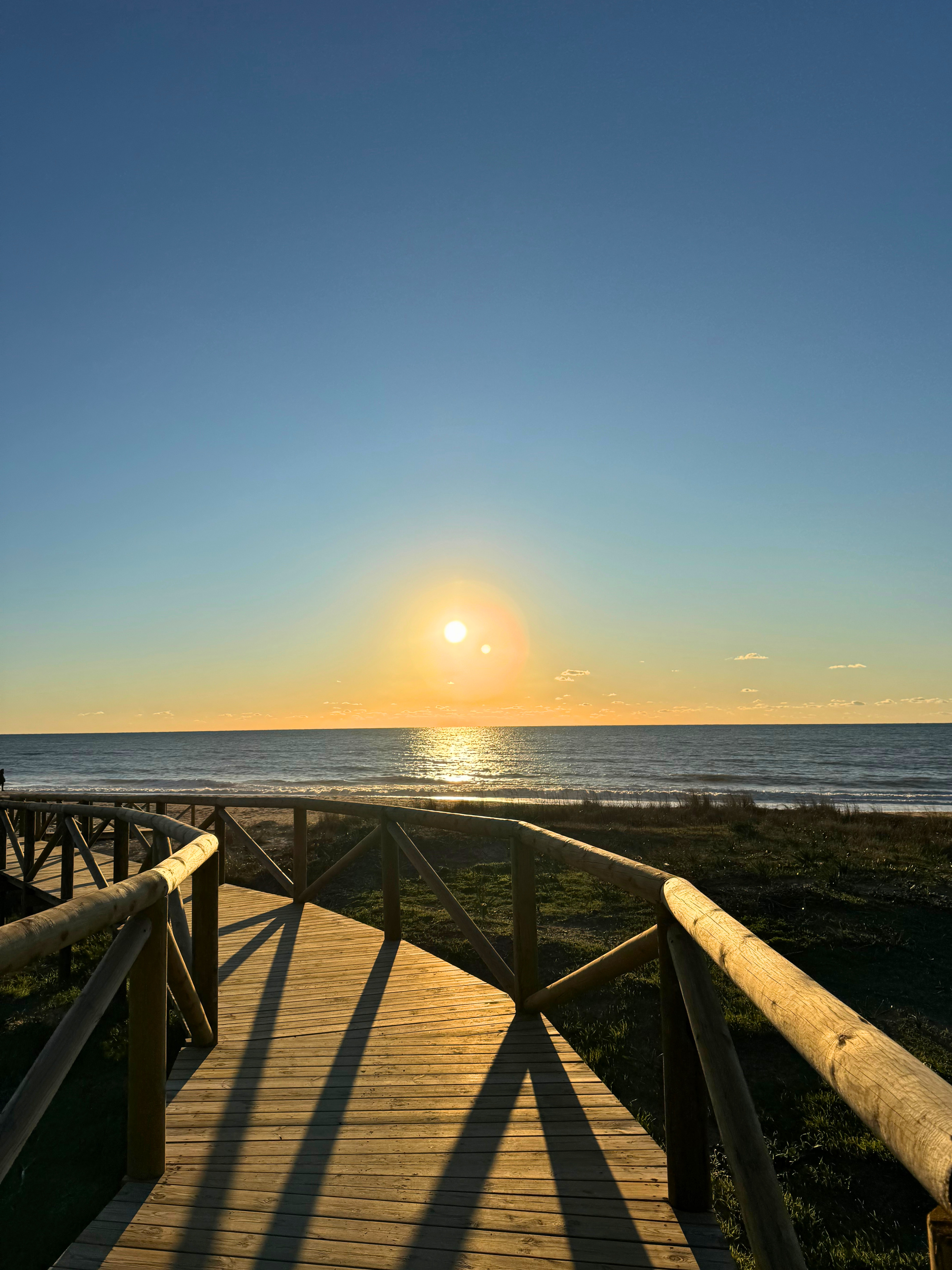 Holzsteg zum Strand bei Sonnenuntergang